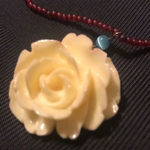 Plastic white rose necklace with red beads